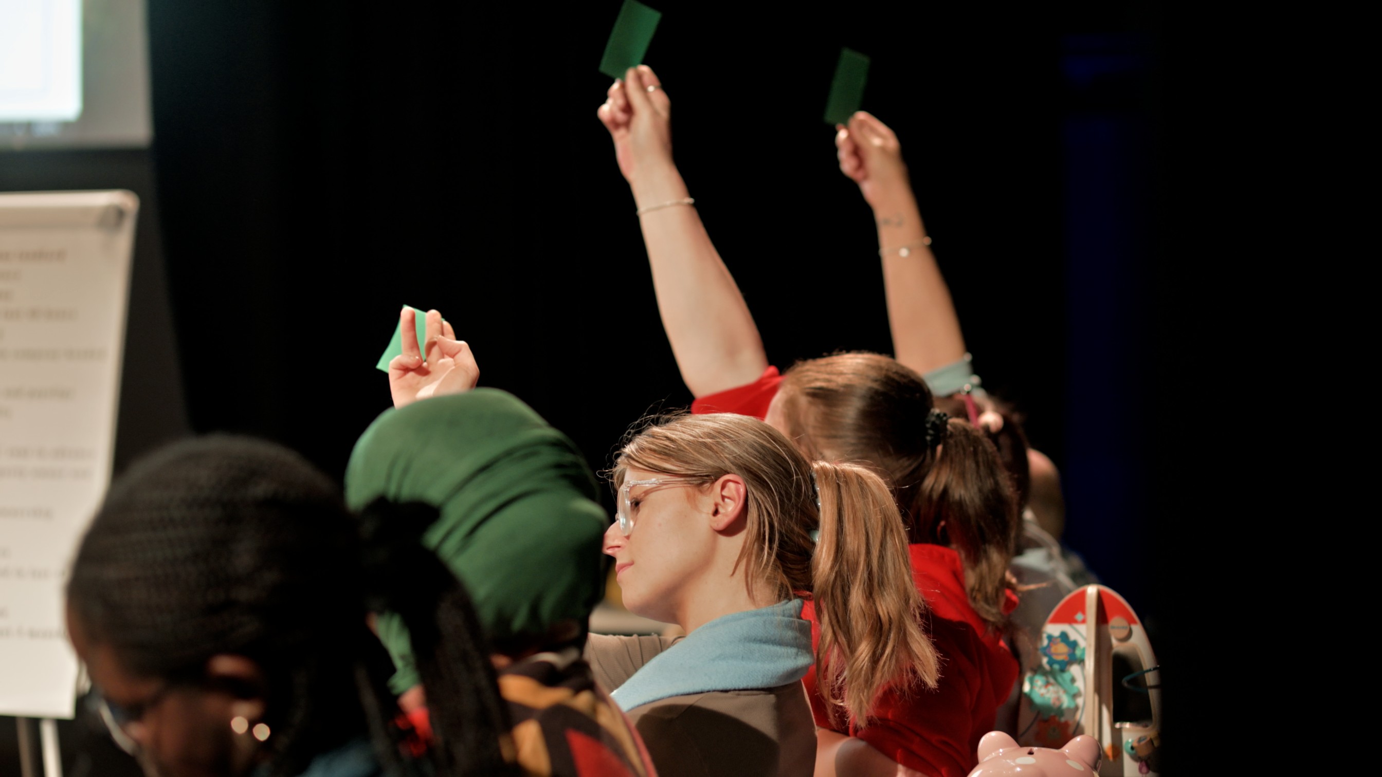 Audience showing green and red cards for questions asked during the play