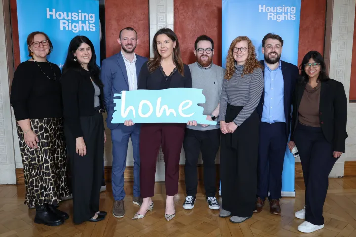 Housing Rights policy team holding a sign saying home 