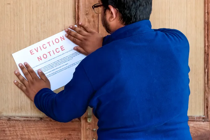 Man sticking eviction notice on the door of the tenant stock photo