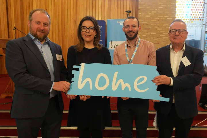 David Polly, Kate M, Jamie Miller, Paddy Gray holding the sign titled Home