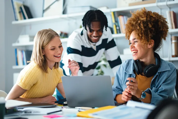 Group of students studying together in a Library with laptops stock photo