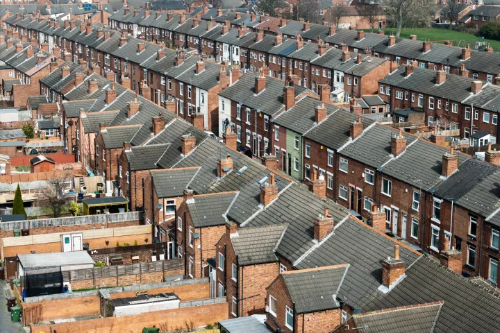 Aerial view above rows of back to back terraced houses on a large council estate