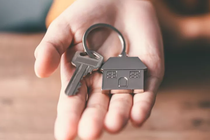 Hand holding a key with house keyring
