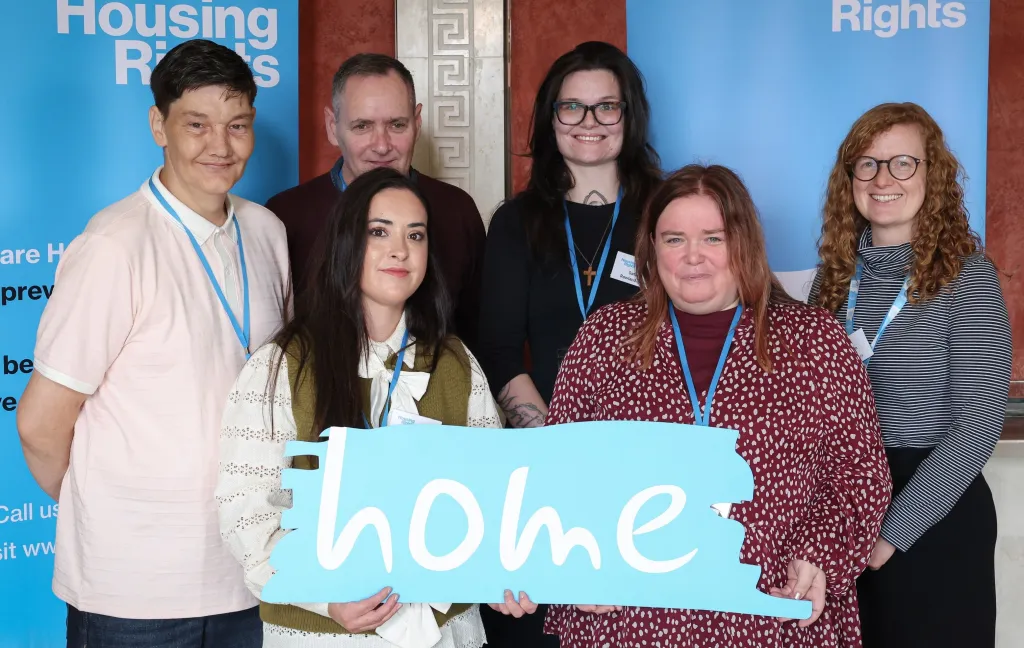 Housing Rights Experts by experience in a group holding a sign saying home